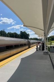 Amtrak Train stopped at the platform while people wait to board the train.